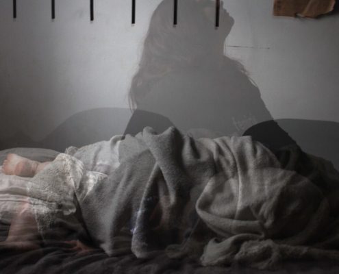 person lying awake in bed during sleep disruption in early methamphetamine recovery