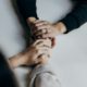 Two people holding hands across a table — couples entering residential rehab together