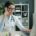 A physician working at a desk with laptop and phone — choosing a residential rehab program