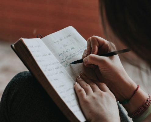 A person writing in a notebook indoors — preparing emotionally for residential addiction treatment