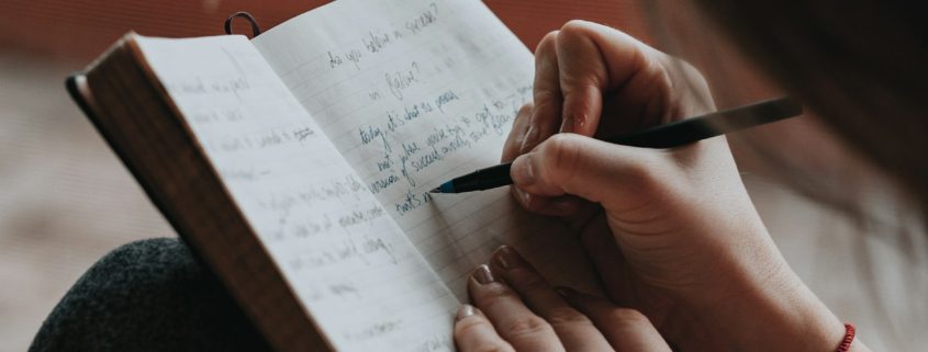 A person writing in a notebook indoors — preparing emotionally for residential addiction treatment