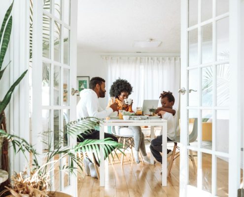 People sitting at a table in a calm indoor conversation — talking to a loved one about rehab