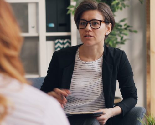 Two women in a couch-based therapy session — trauma-informed residential addiction treatment